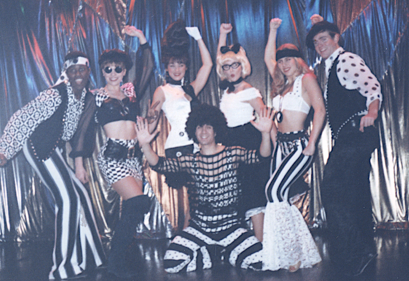 A group of people in costumes on stage.